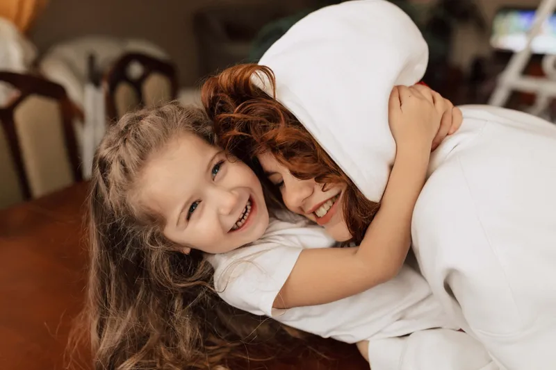 Madre e hija mirando juntas por un balcón